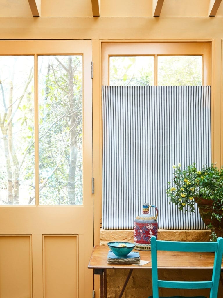 Sun room painted with Chalk Paint® by Annie Sloan in Arles. The chair is in Provence and blind is Ticking fabric in Graphite