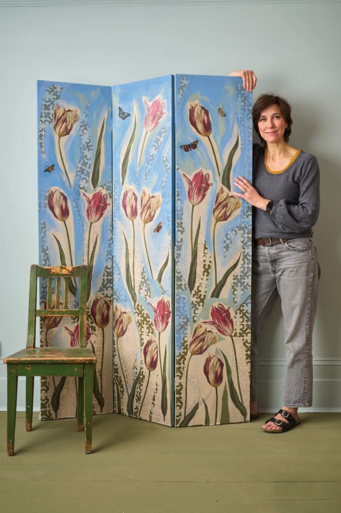 Designer Joanna Standing Next to Her Decoupage Screen Creation