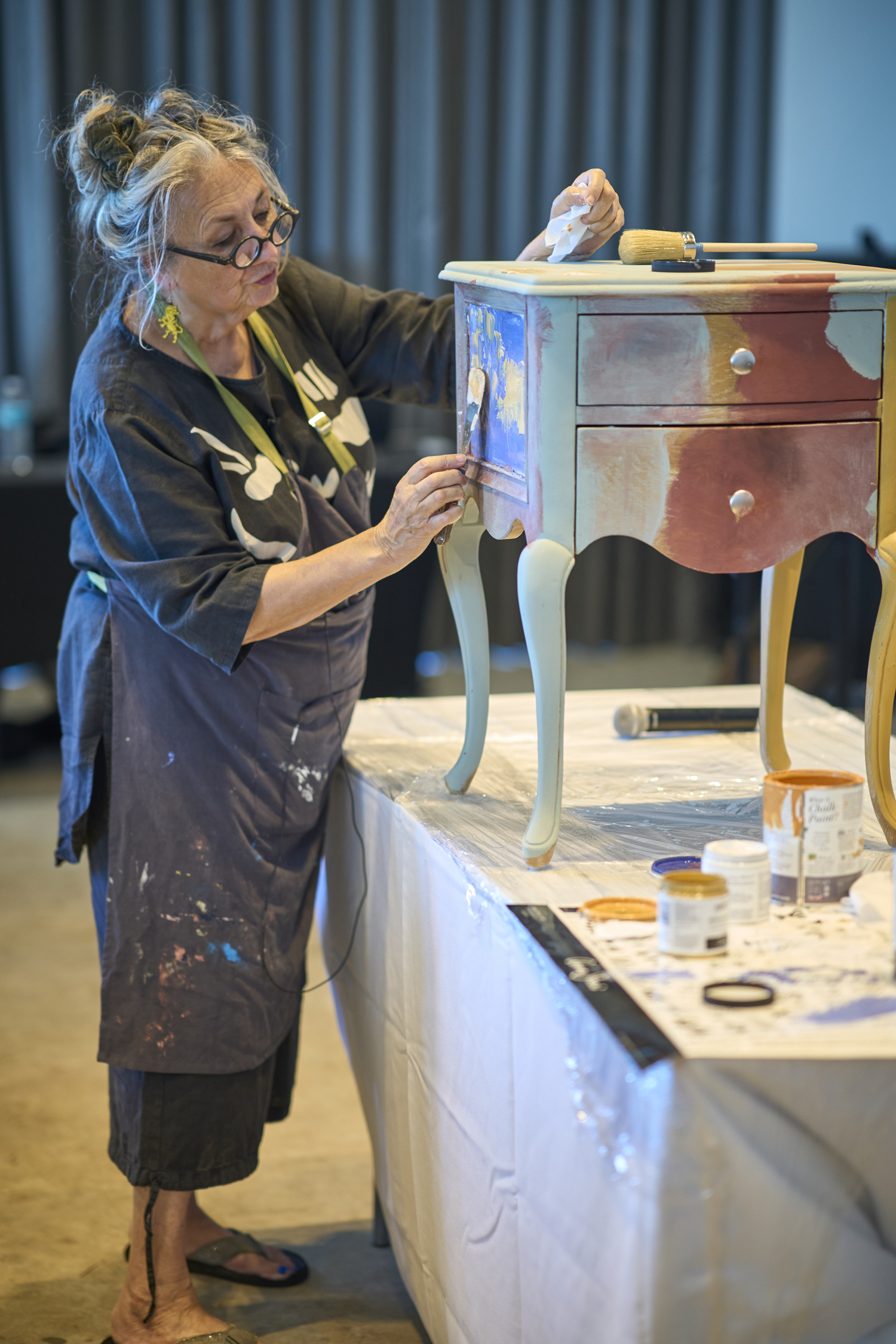 Annie Sloan giving a furniture painting demonstration on a small side table in NOLA